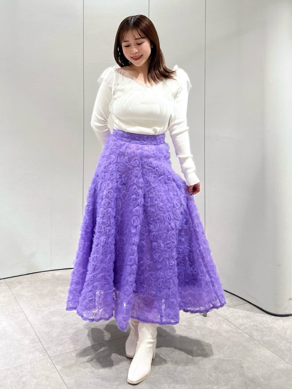 ホワイト系のブーツ、ホワイト系のニット/セーター、パープル系のスカートを着用したレディースの秋コーディネートの2枚目の写真