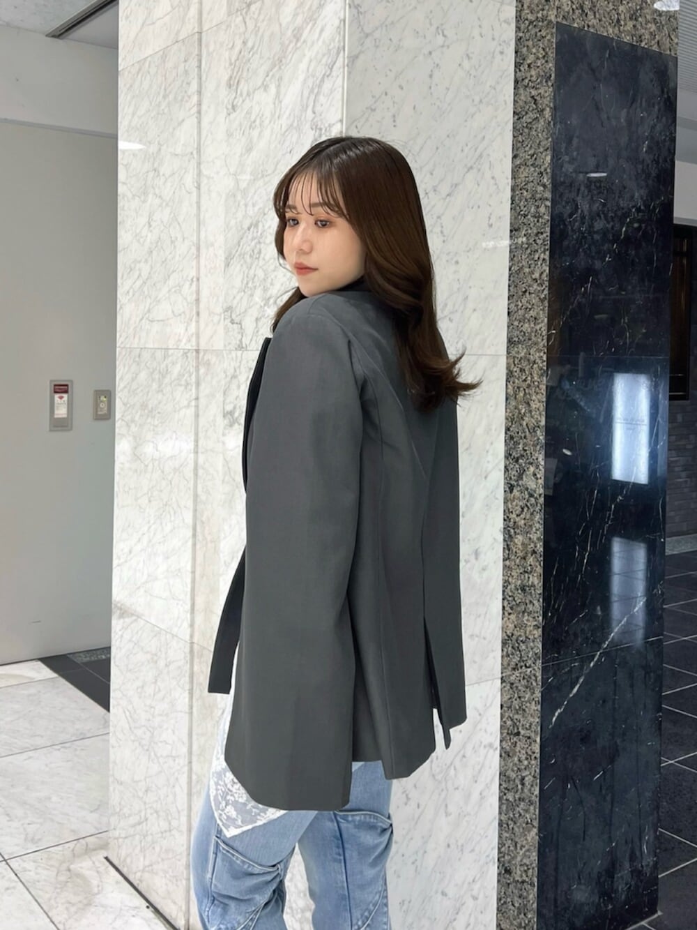 ブラック系のニット/セーター、ブラック系のブーツ、グレー系のテーラードジャケットを着用したレディースの冬コーディネートの6枚目の写真