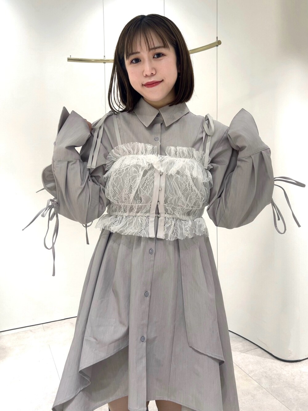 ホワイト系のキャミソール、グレー系のシャツワンピース、ブラック系のブーツを着用したレディースの秋コーディネートの4枚目の写真