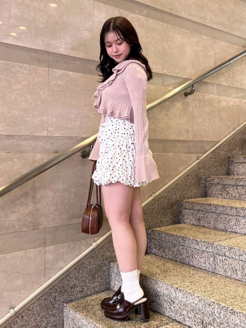 ホワイト系のキャミソール、ホワイト系のスカート、ピンク系のカーディガン/ボレロを着用したレディースの春コーディネートの3枚目の写真