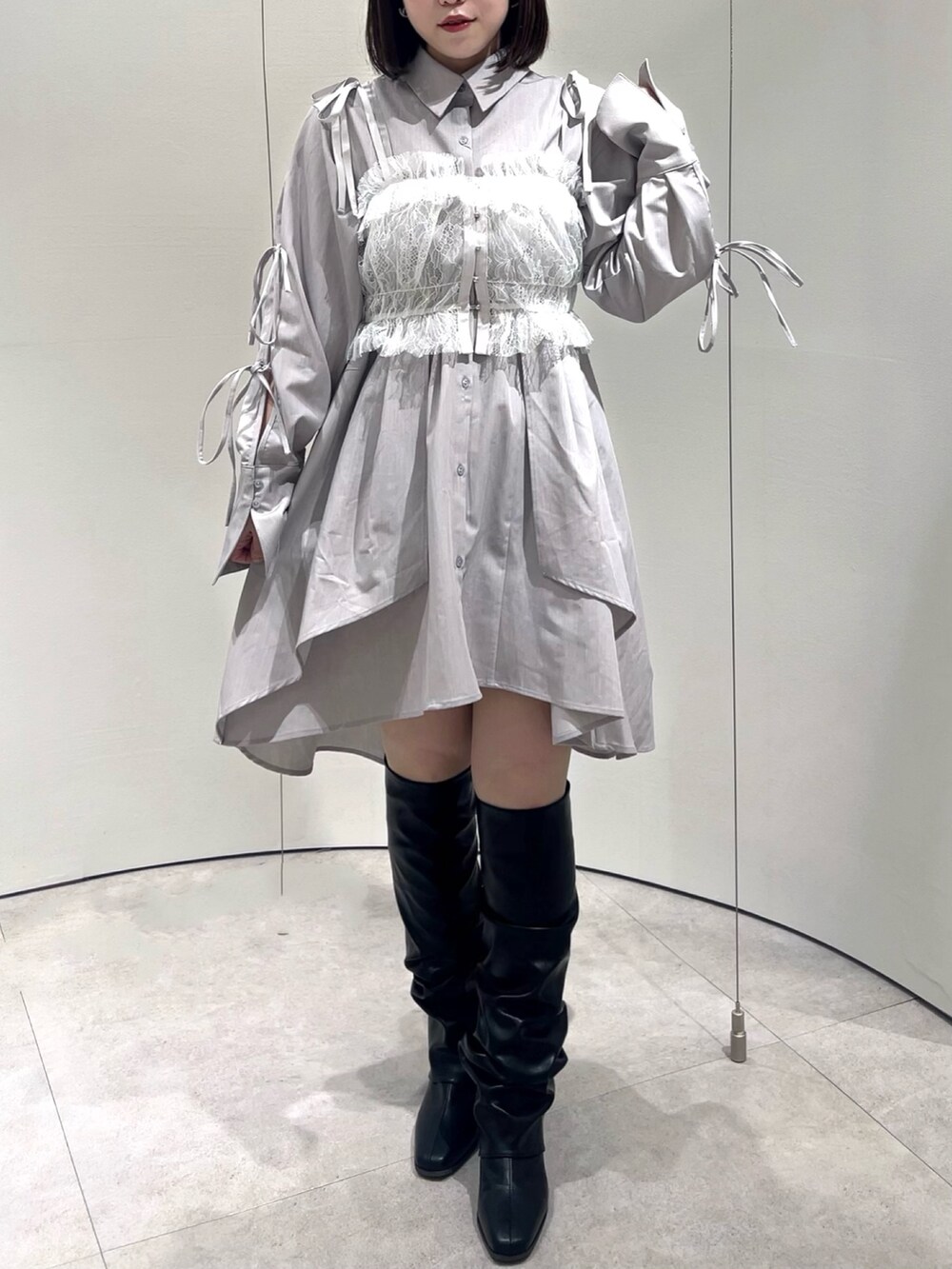 ホワイト系のキャミソール、グレー系のシャツワンピース、ブラック系のブーツを着用したレディースの秋コーディネートの3枚目の写真