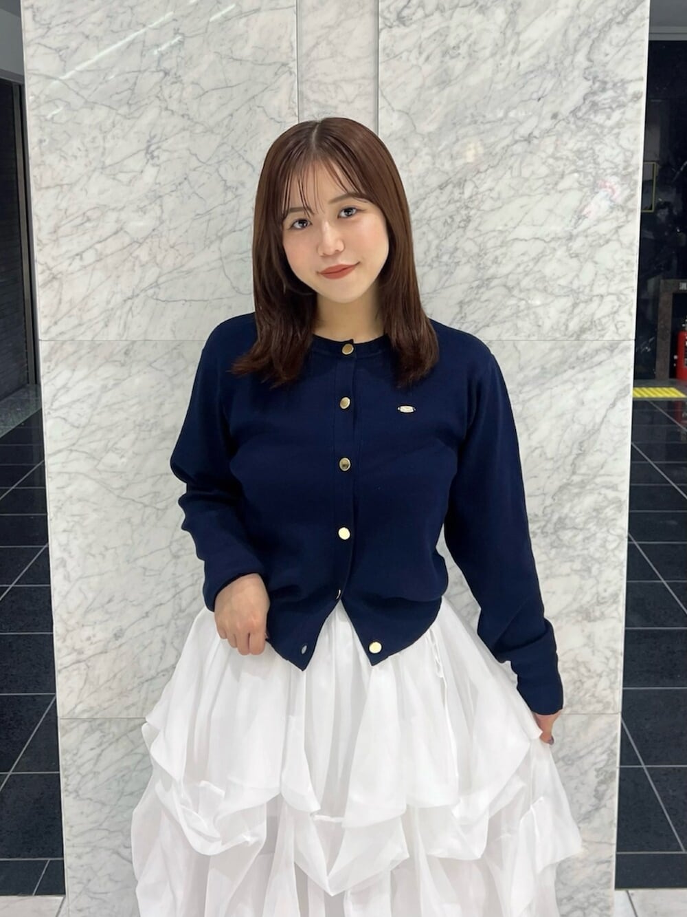 ブルー系のカーディガン/ボレロ、ホワイト系のスカート、ホワイト系のブーツを着用したレディースの秋コーディネートの6枚目の写真