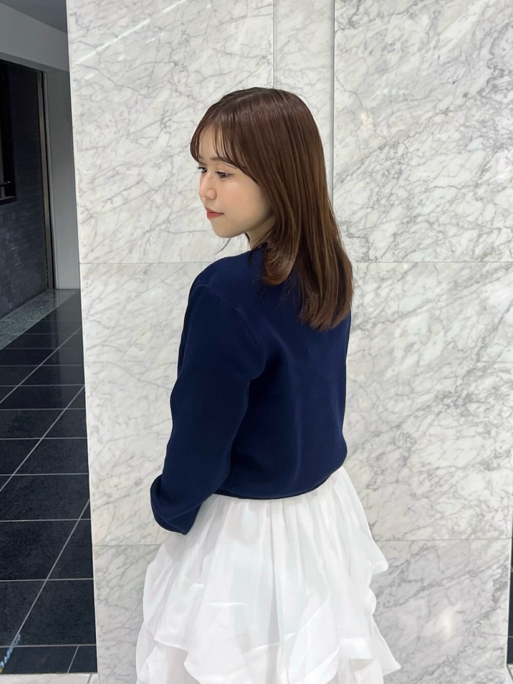 ブルー系のカーディガン/ボレロ、ホワイト系のスカート、ホワイト系のブーツを着用したレディースの秋コーディネートの8枚目の写真