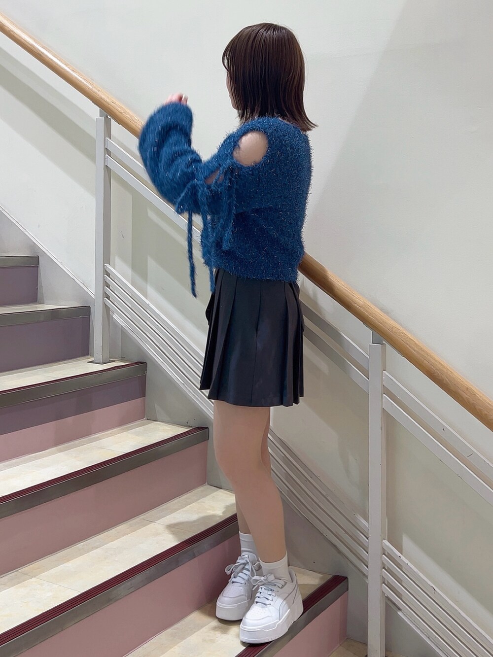 グレー系のスカート、ホワイト系のその他シューズ、ブルー系のニット/セーターを着用したレディースの夏コーディネートの3枚目の写真