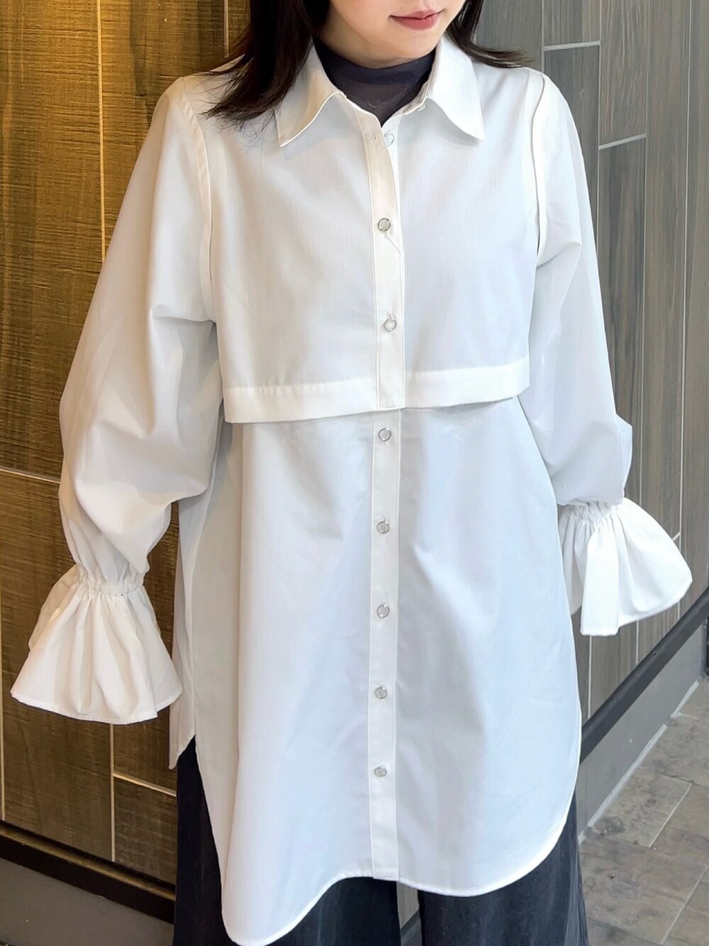 ホワイト系のワンピース、ブラック系のデニムパンツ、ブラック系のブーツを着用したレディースの春コーディネートの5枚目の写真