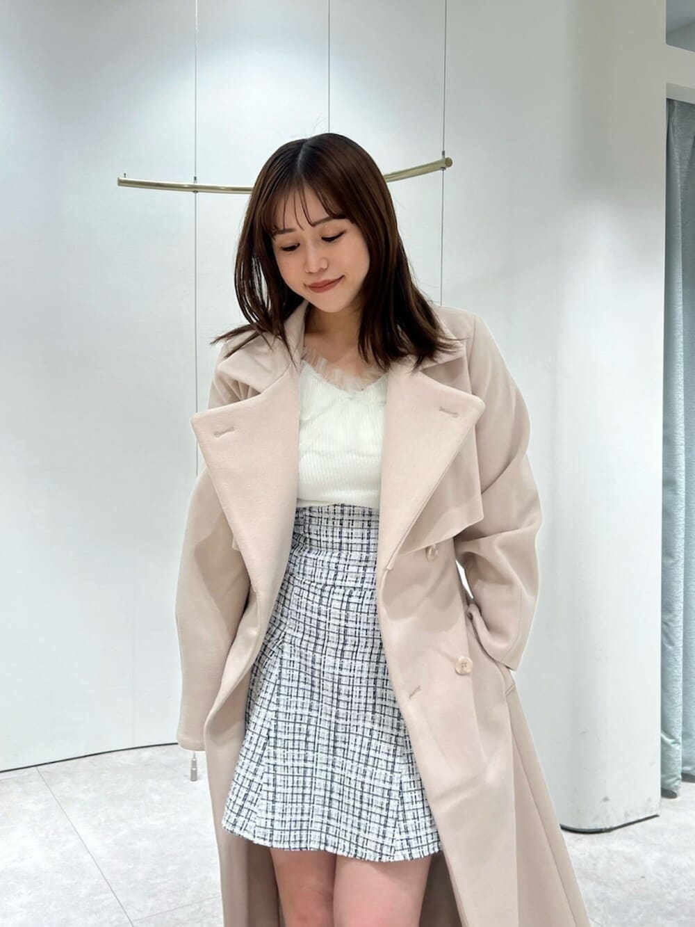 ホワイト系のブーツ、その他のスカート、ピンク系のトレンチコートを着用したレディースの秋コーディネートの5枚目の写真