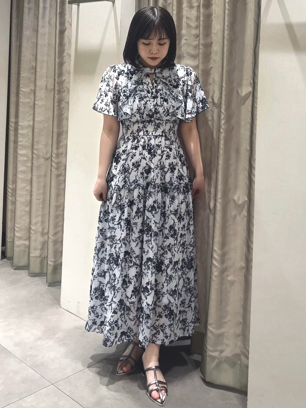 ホワイト系のワンピース、シルバー系のパンプスを着用したレディースの春コーディネートの3枚目の写真