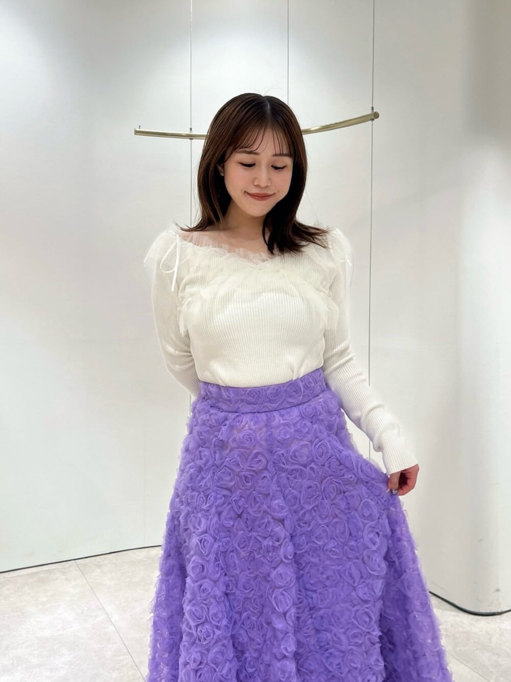 ホワイト系のブーツ、ホワイト系のニット/セーター、パープル系のスカートを着用したレディースの秋コーディネートの4枚目の写真