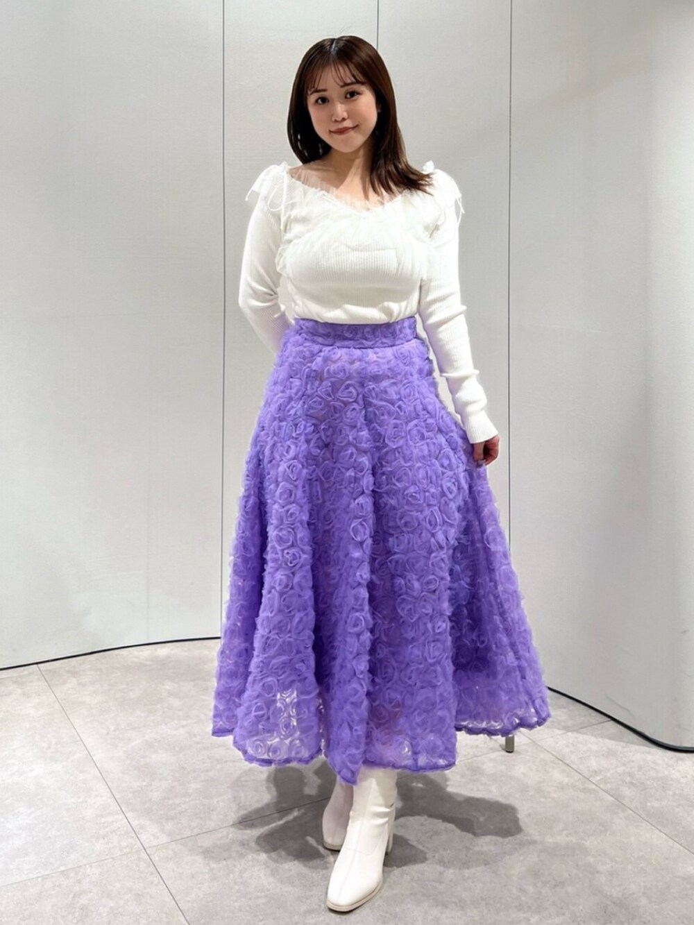 ホワイト系のブーツ、ホワイト系のニット/セーター、パープル系のスカートを着用したレディースの秋コーディネートの3枚目の写真