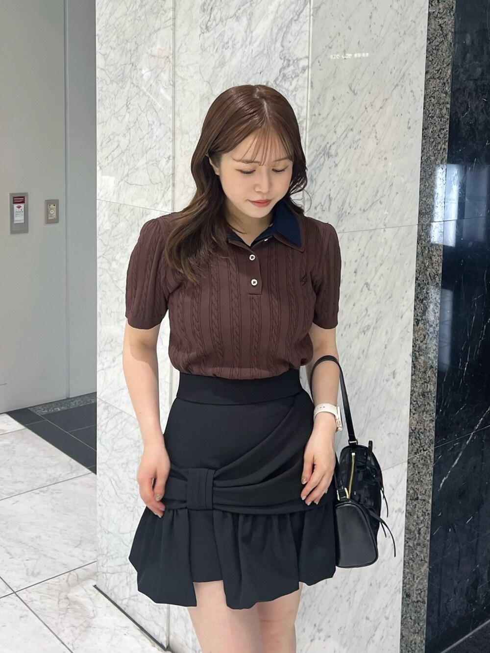 ブラウン系のニット/セーター、ブラック系のスカート、ブラック系のサンダルを着用したレディースの夏コーディネートの5枚目の写真