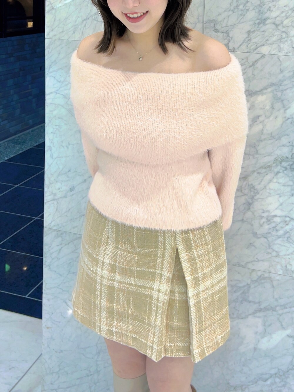 ピンク系のニット/セーター、ベージュ系のスカート、ベージュ系のブーツを着用したレディースの冬コーディネートの5枚目の写真