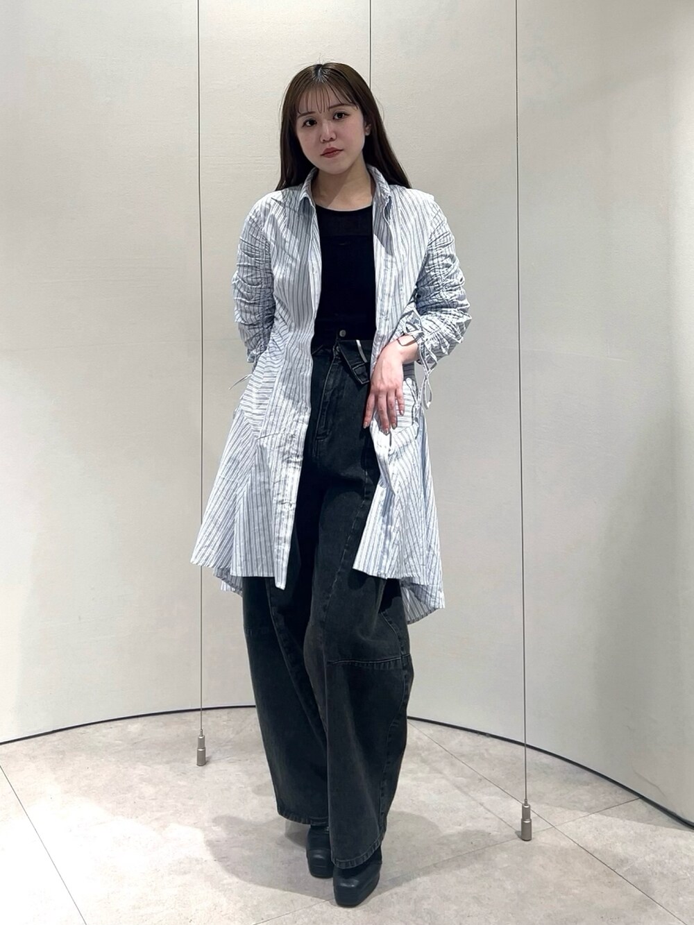 ブラック系のTシャツ/カットソー、ブラック系のデニムパンツ、その他のワンピースを着用したレディースの春コーディネートの4枚目の写真