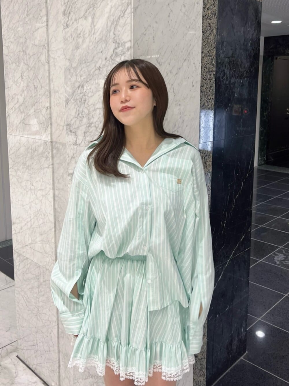 グリーン系のシャツ/ブラウス、グリーン系のスカート、ブラウン系のブーツを着用したレディースの春コーディネートの5枚目の写真