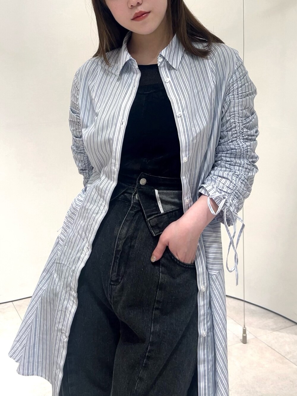 ブラック系のTシャツ/カットソー、ブラック系のデニムパンツ、その他のワンピースを着用したレディースの春コーディネートの6枚目の写真