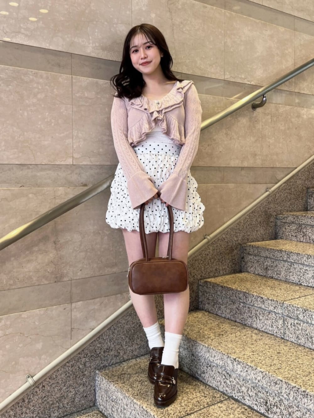 ホワイト系のキャミソール、ホワイト系のスカート、ピンク系のカーディガン/ボレロを着用したレディースの春コーディネートの2枚目の写真