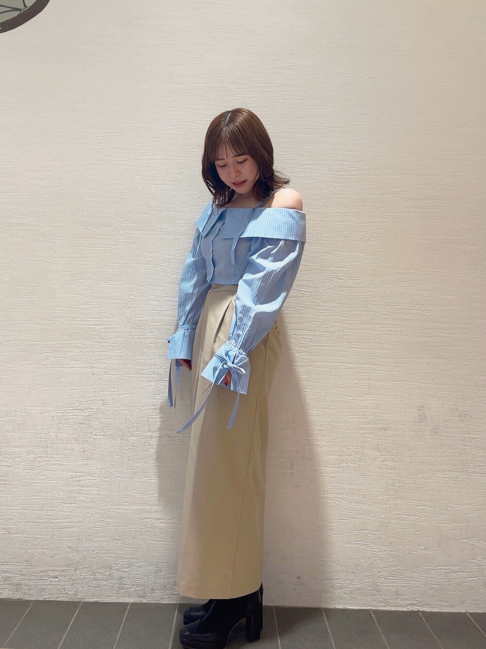 ホワイト系のシャツ/ブラウス、ブラック系のブーツ、グレー系のスカートを着用したレディースの冬コーディネートの3枚目の写真