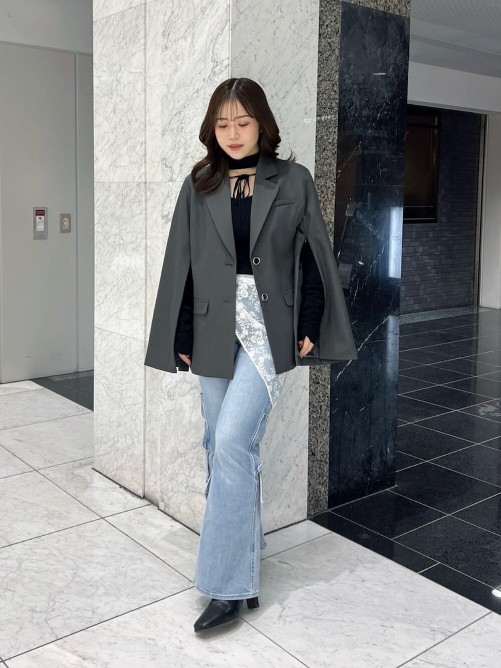 ブラック系のニット/セーター、ブラック系のブーツ、グレー系のテーラードジャケットを着用したレディースの冬コーディネートの4枚目の写真