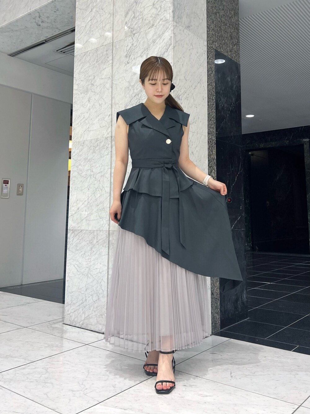 グレー系のワンピース、ブラック系のサンダルを着用したレディースの夏コーディネートの3枚目の写真