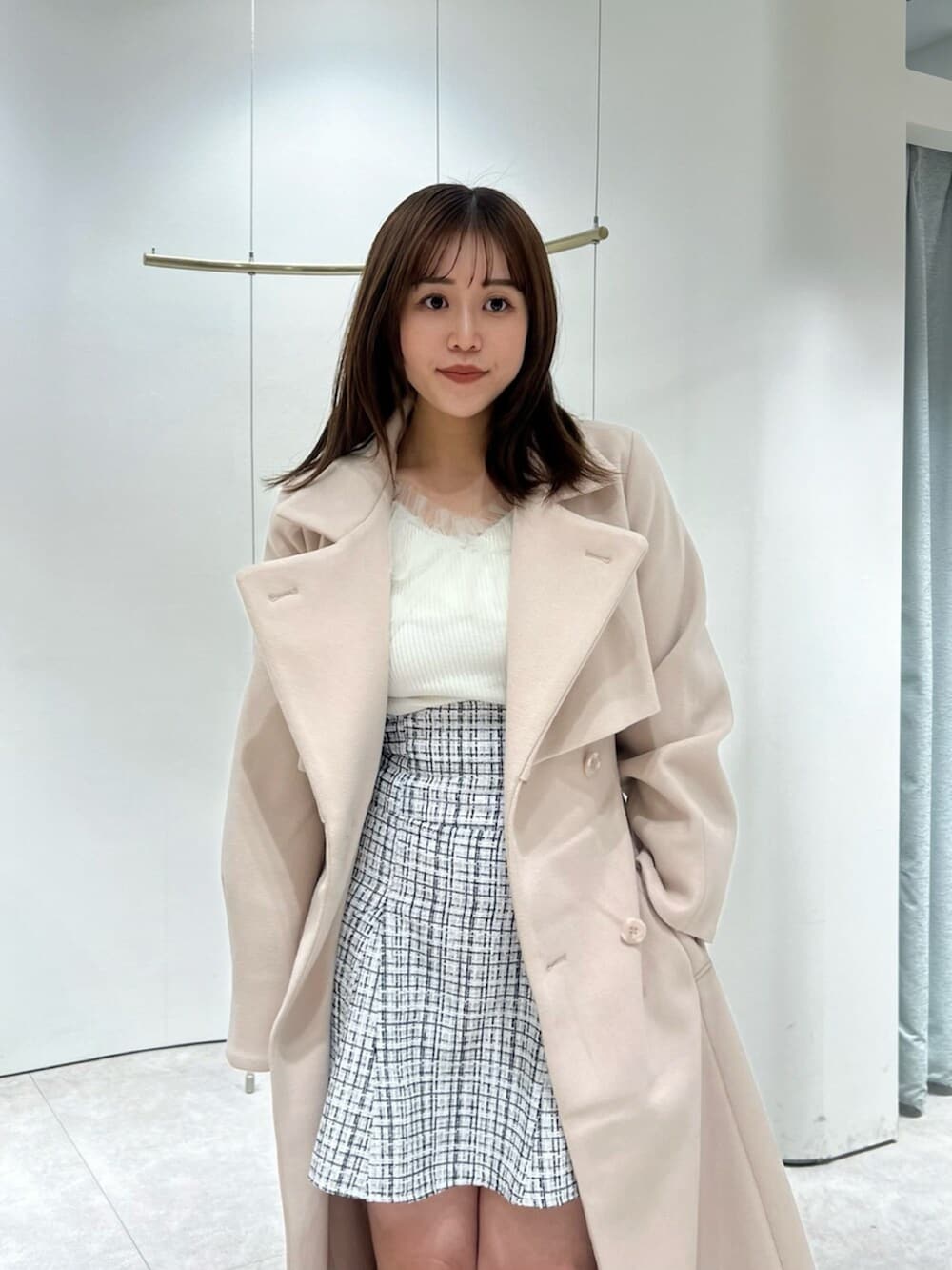 ホワイト系のブーツ、その他のスカート、ピンク系のトレンチコートを着用したレディースの秋コーディネートの6枚目の写真