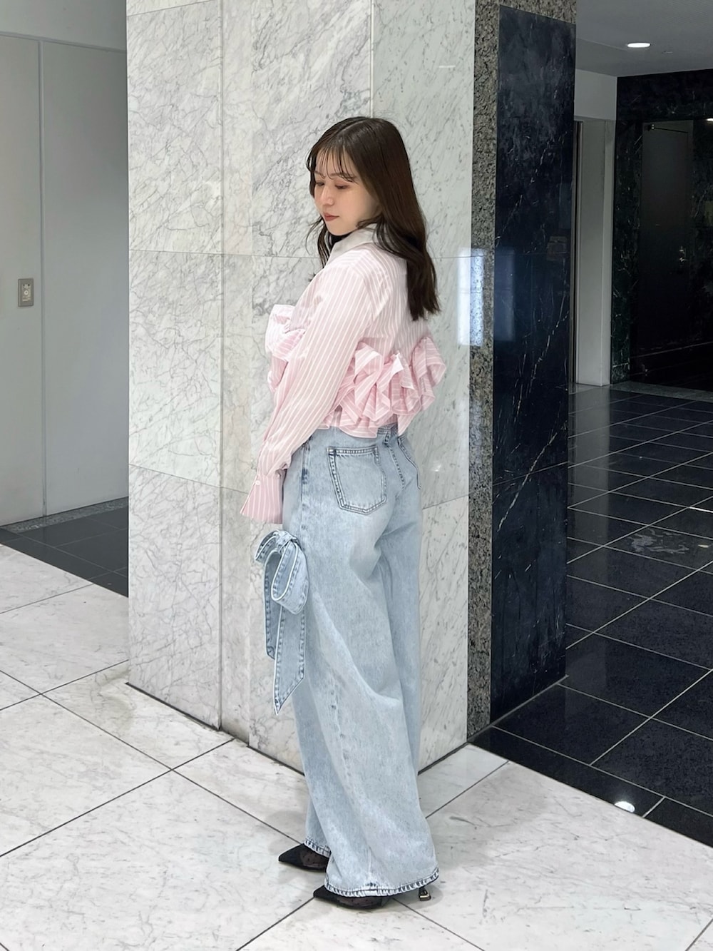 ピンク系のシャツ/ブラウス、ブルー系のデニムパンツ、ブラック系のパンプスを着用したレディースの春コーディネートの3枚目の写真