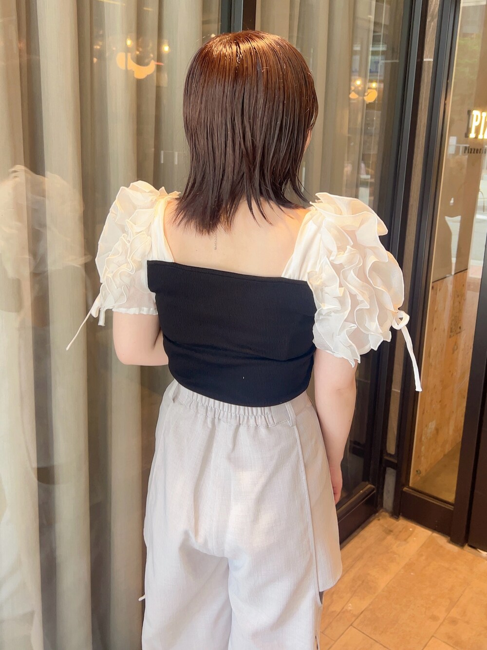 ブラック系のTシャツ/カットソー、グレー系のチノパンツ、ブラック系のサンダルを着用したレディースの夏コーディネートの6枚目の写真