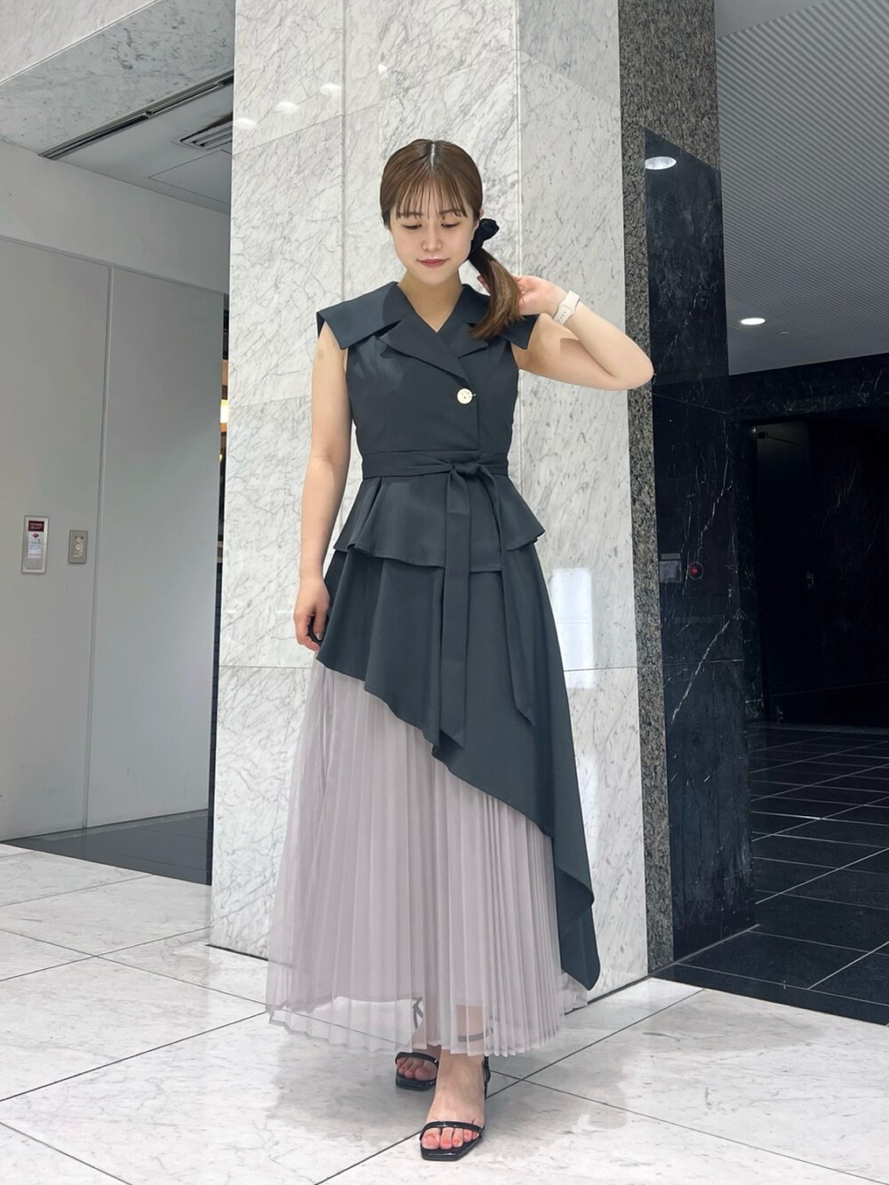 グレー系のワンピース、ブラック系のサンダルを着用したレディースの夏コーディネートの2枚目の写真