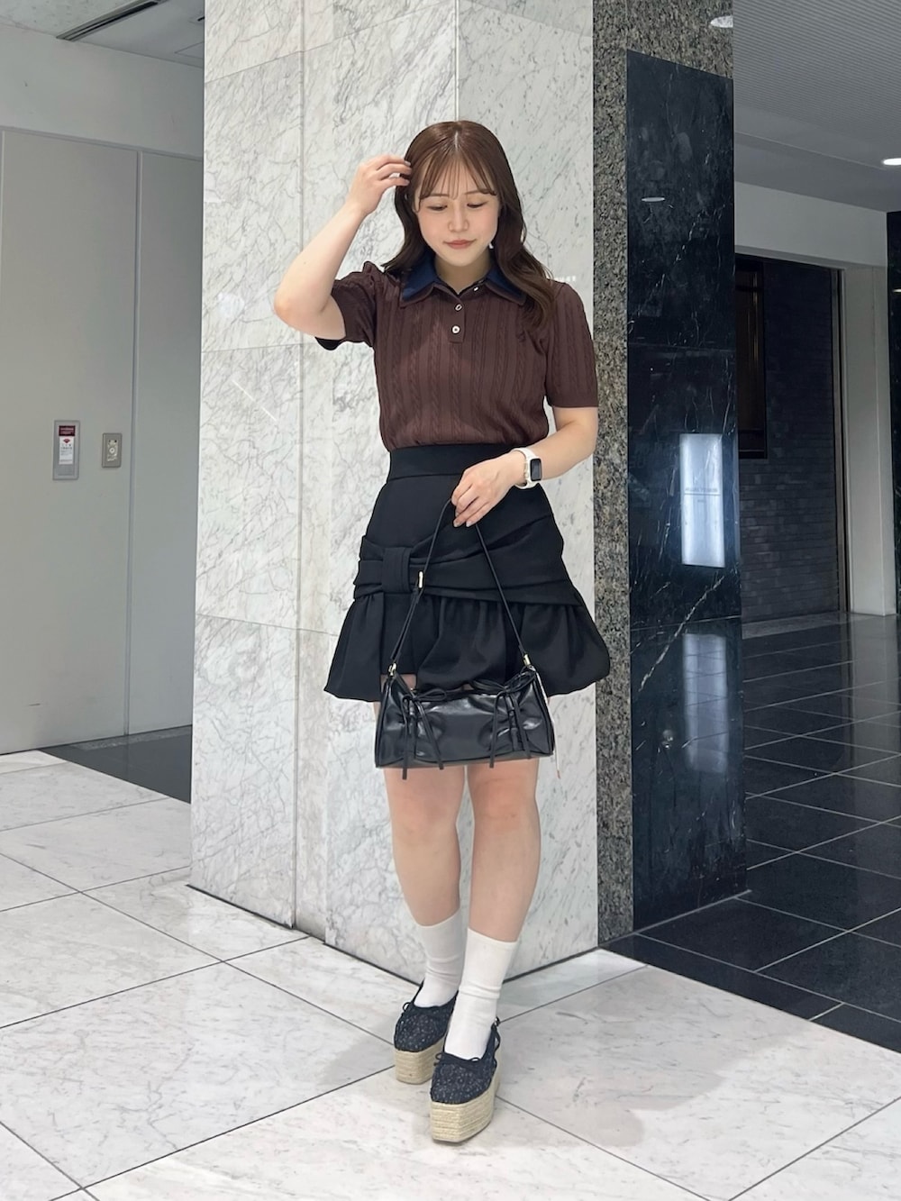 ブラウン系のニット/セーター、ブラック系のスカート、ブラック系のサンダルを着用したレディースの夏コーディネートの3枚目の写真