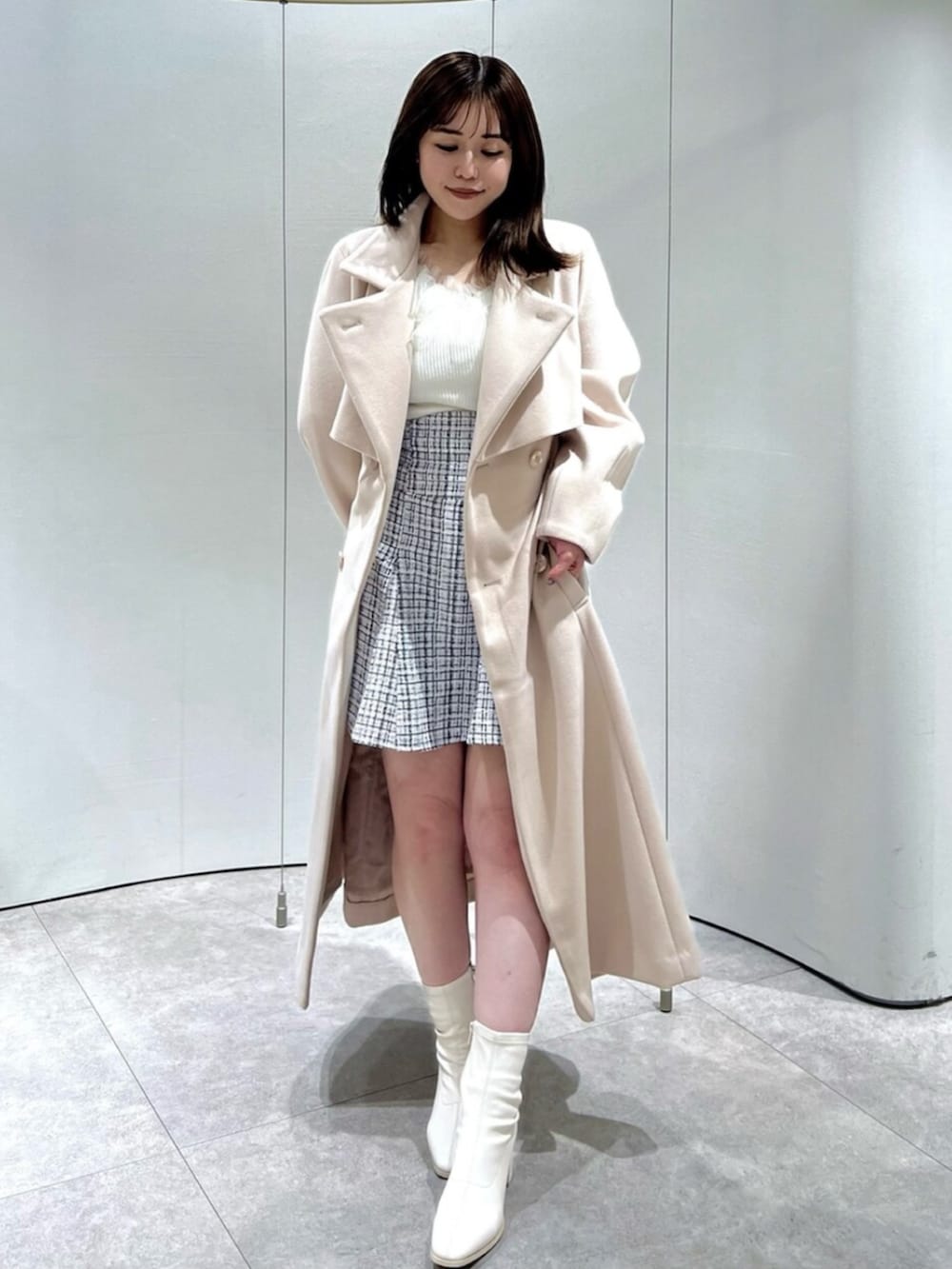 ホワイト系のブーツ、その他のスカート、ピンク系のトレンチコートを着用したレディースの秋コーディネートの2枚目の写真