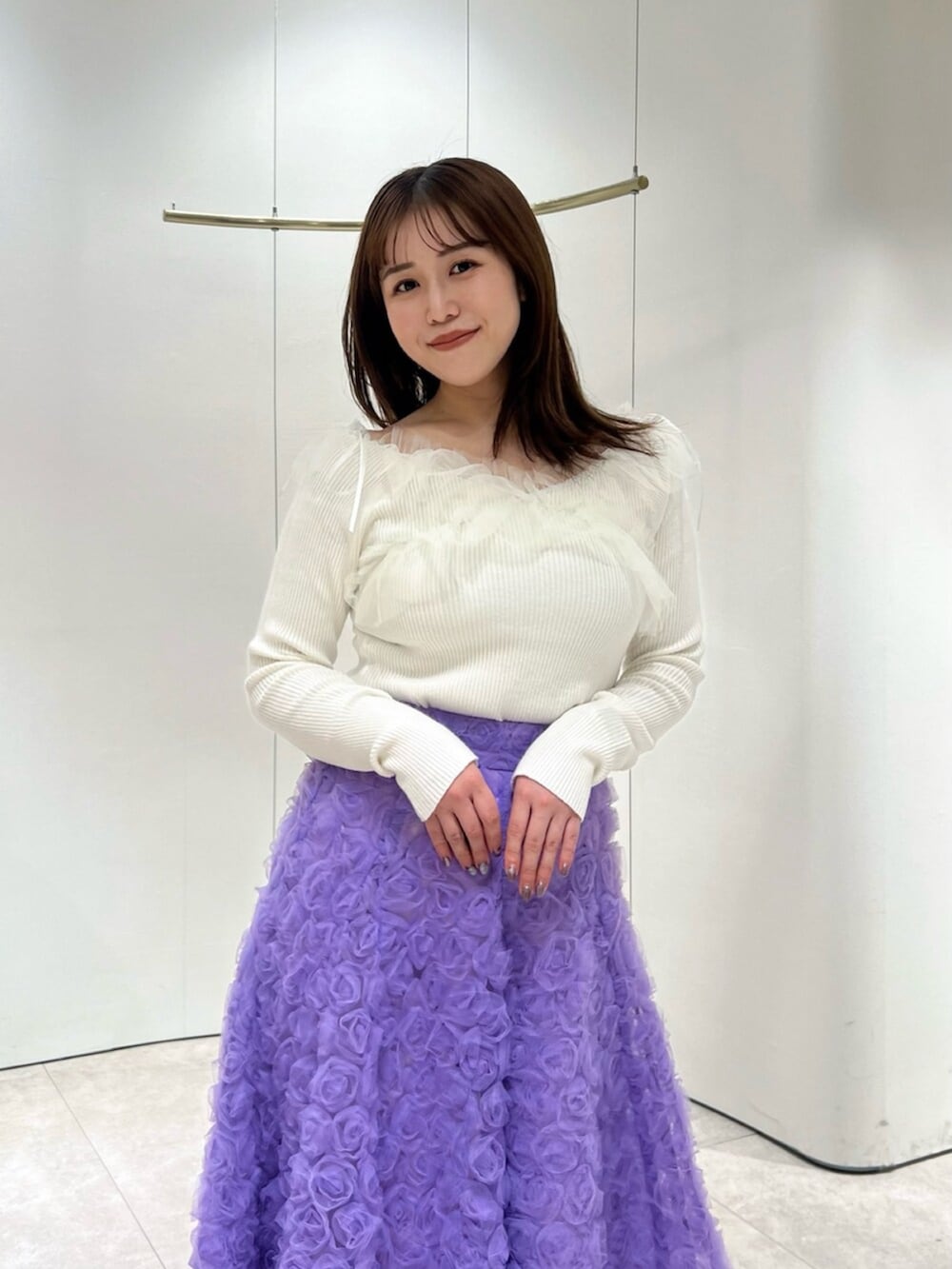 ホワイト系のブーツ、ホワイト系のニット/セーター、パープル系のスカートを着用したレディースの秋コーディネートの5枚目の写真