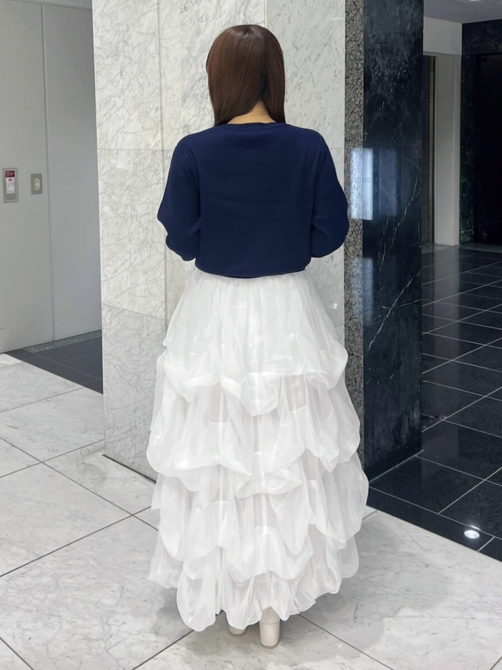 ブルー系のカーディガン/ボレロ、ホワイト系のスカート、ホワイト系のブーツを着用したレディースの秋コーディネートの5枚目の写真