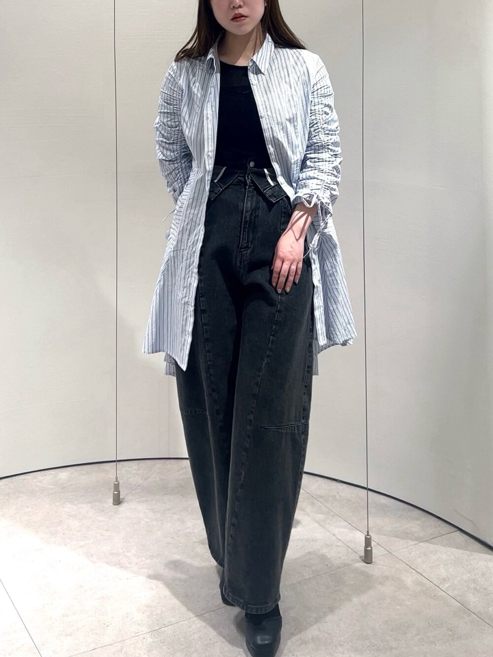 ブラック系のTシャツ/カットソー、ブラック系のデニムパンツ、その他のワンピースを着用したレディースの春コーディネートの3枚目の写真