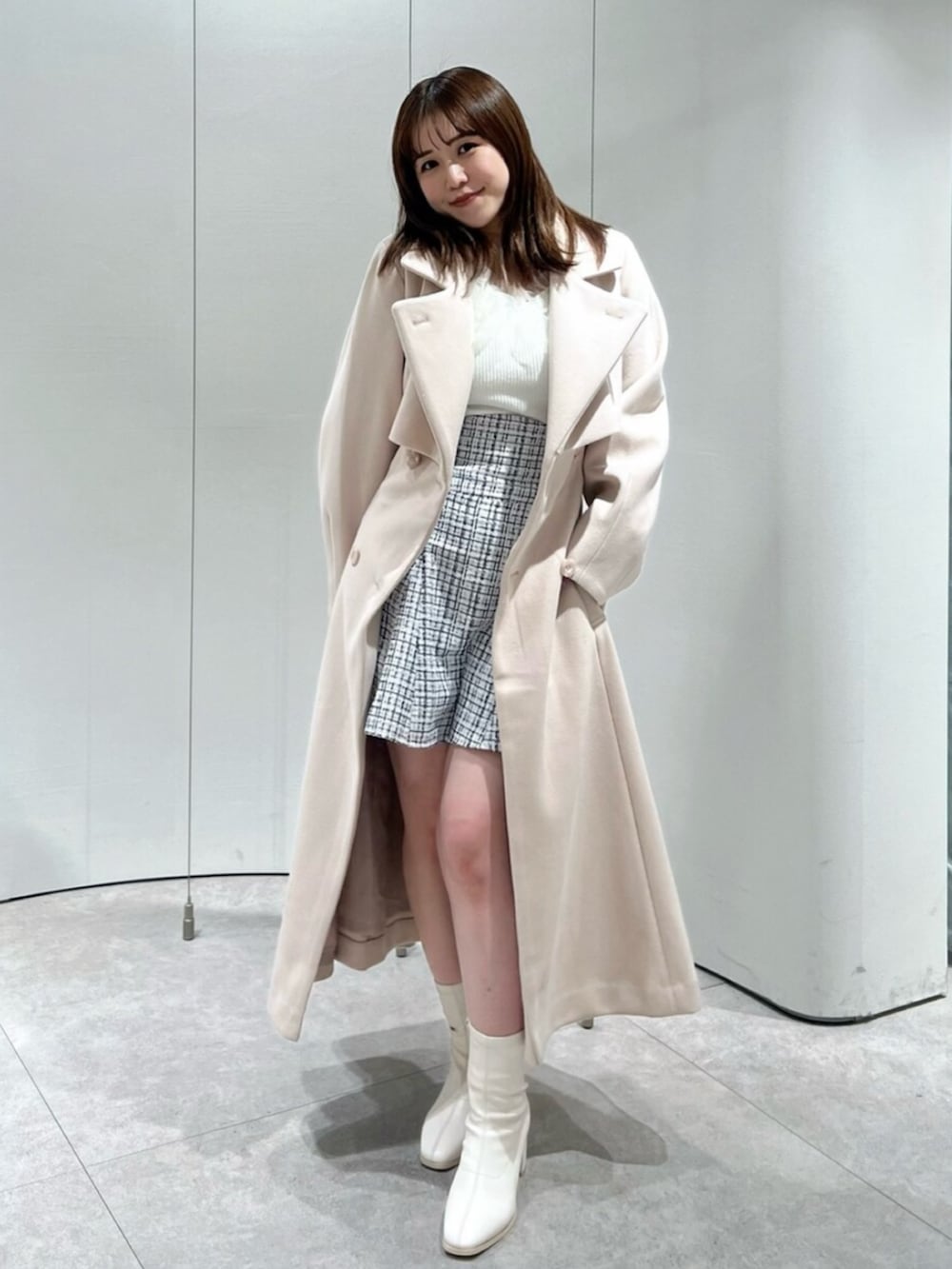 ホワイト系のブーツ、その他のスカート、ピンク系のトレンチコートを着用したレディースの秋コーディネートの4枚目の写真