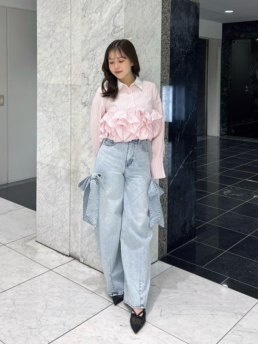 ピンク系のシャツ/ブラウス、ブルー系のデニムパンツ、ブラック系のパンプスを着用したレディースの春コーディネートの2枚目の写真