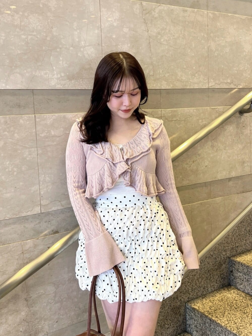 ホワイト系のキャミソール、ホワイト系のスカート、ピンク系のカーディガン/ボレロを着用したレディースの春コーディネートの6枚目の写真