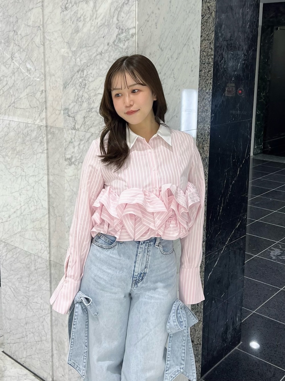 ピンク系のシャツ/ブラウス、ブルー系のデニムパンツ、ブラック系のパンプスを着用したレディースの春コーディネートの5枚目の写真