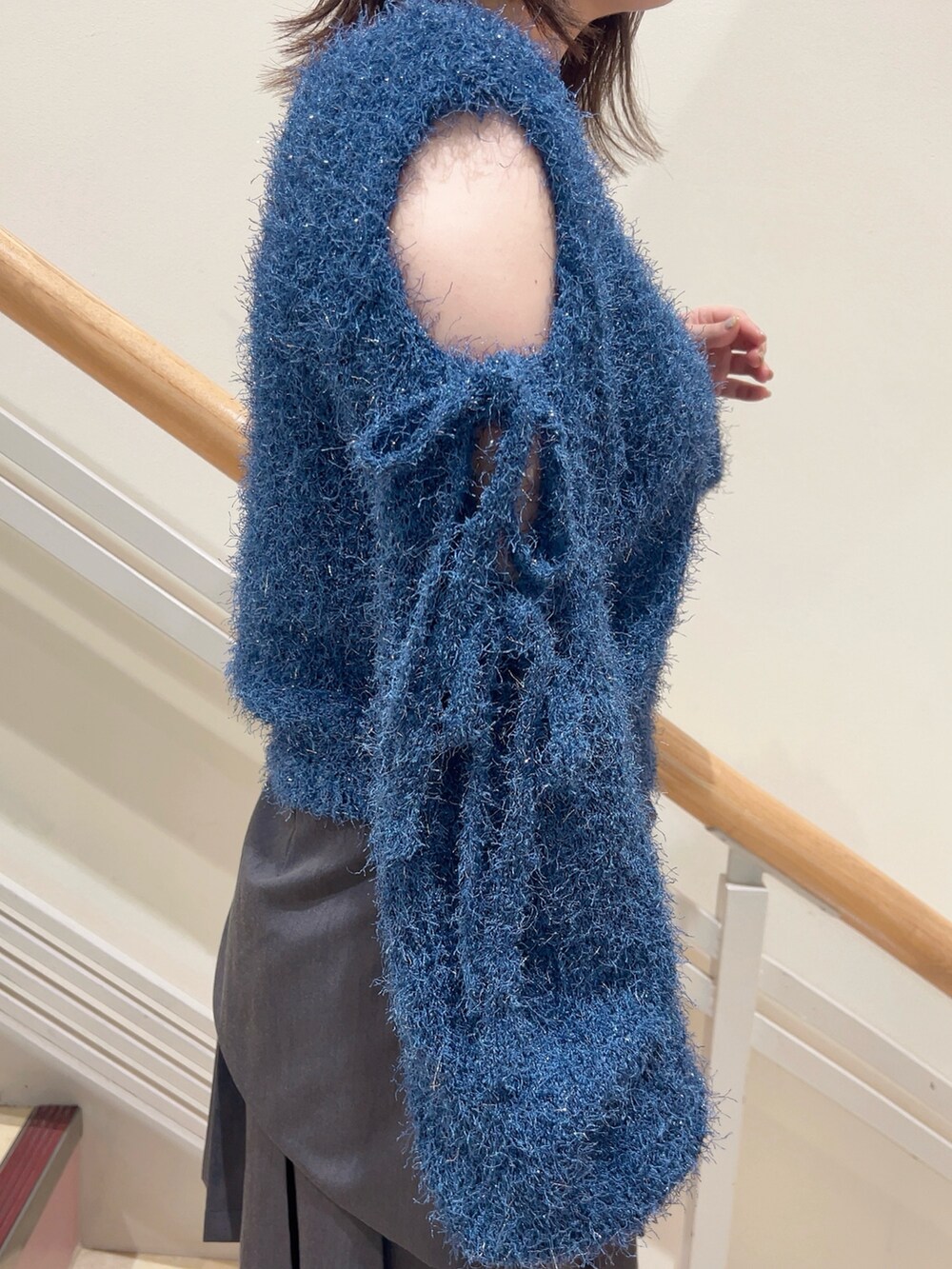 グレー系のスカート、ホワイト系のその他シューズ、ブルー系のニット/セーターを着用したレディースの夏コーディネートの6枚目の写真