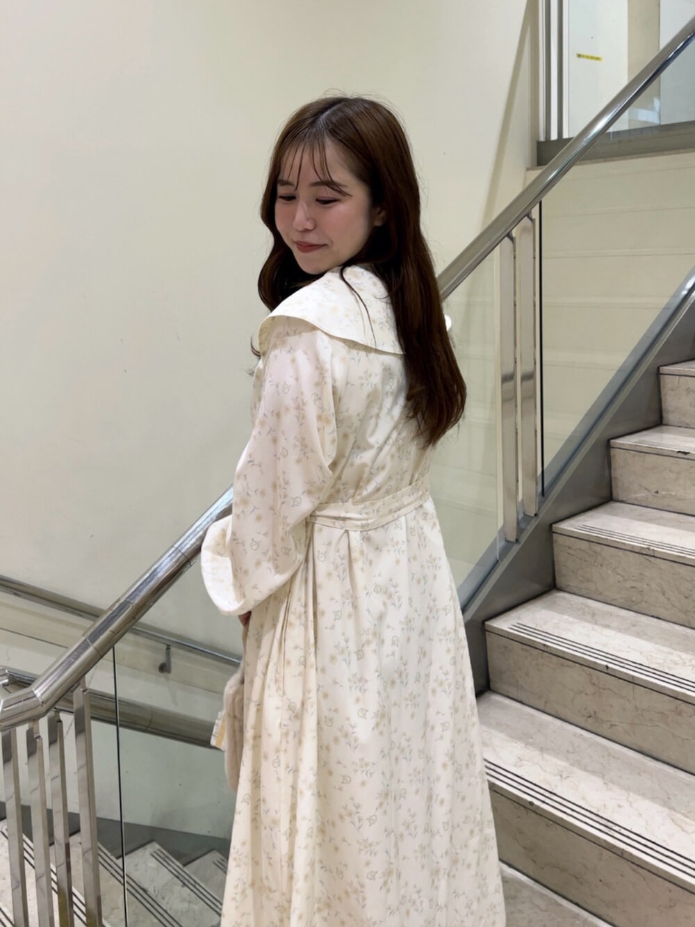 イエロー系のワンピース、イエロー系のハンドバッグ、ホワイト系のパンプスを着用したレディースの秋コーディネートの7枚目の写真