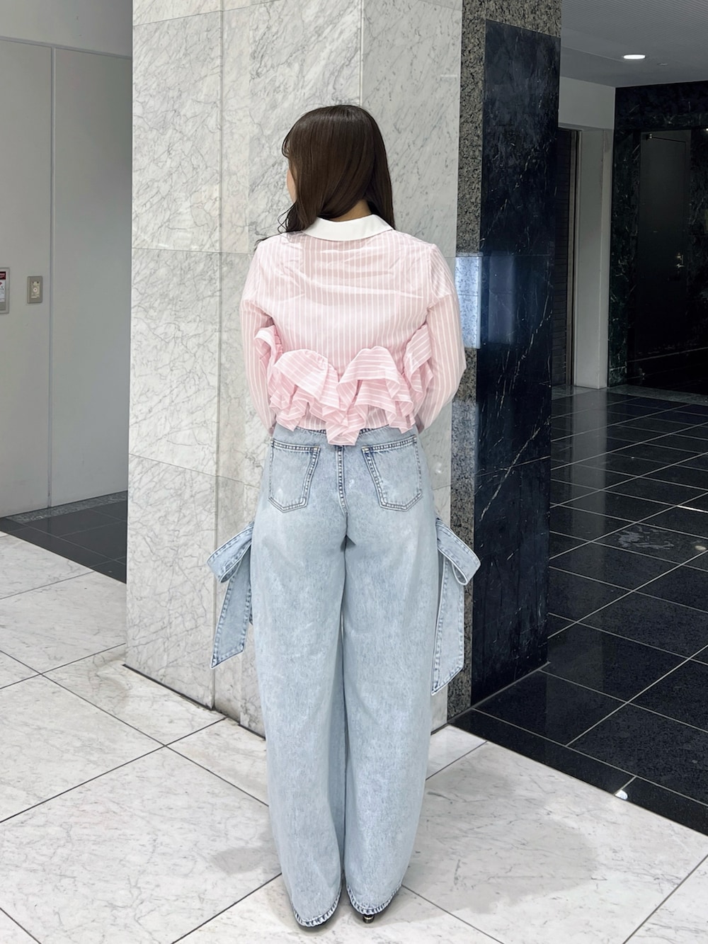 ピンク系のシャツ/ブラウス、ブルー系のデニムパンツ、ブラック系のパンプスを着用したレディースの春コーディネートの4枚目の写真