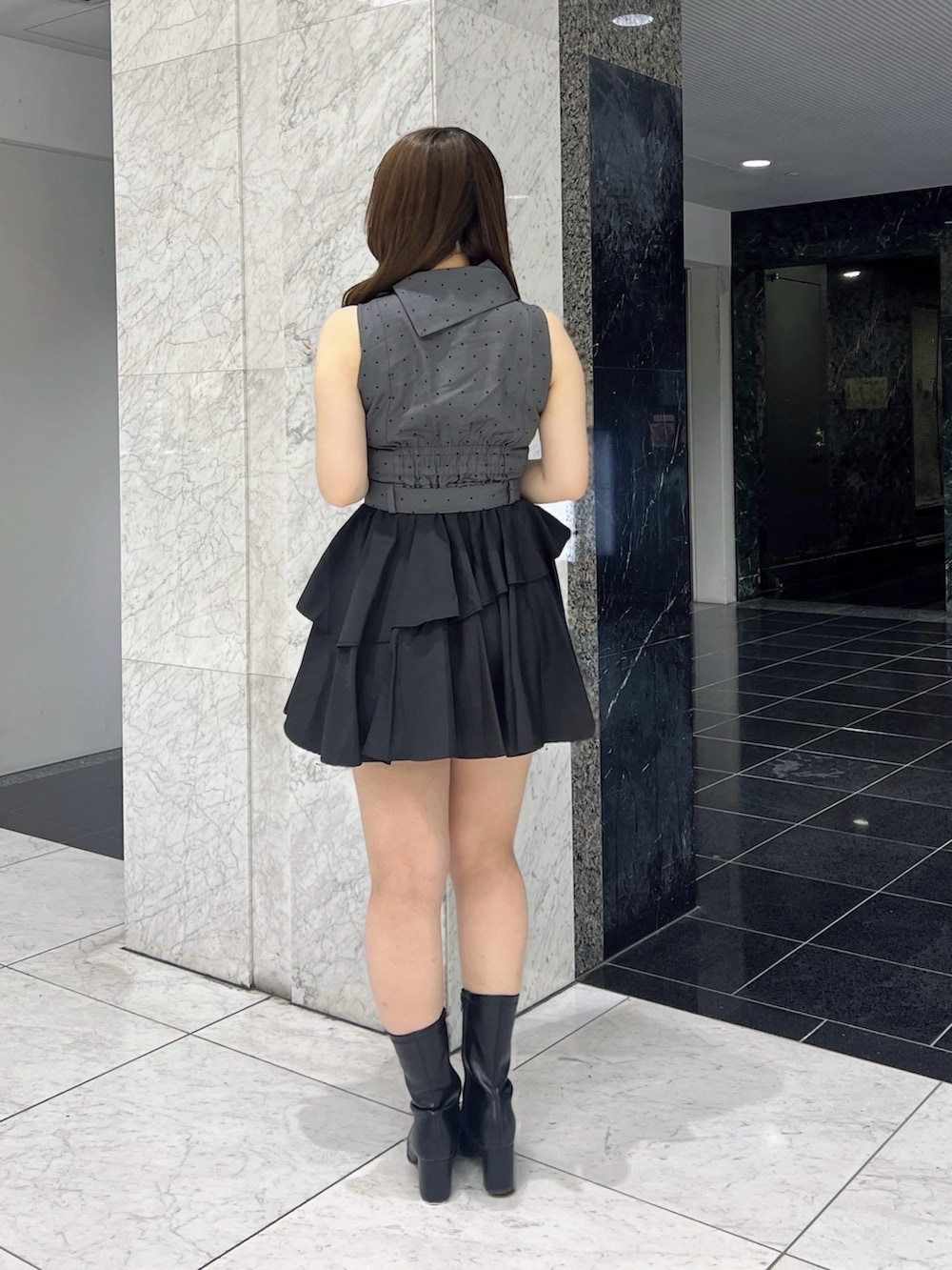 ブラック系のワンピース、ブラック系のブーツを着用したレディースの夏コーディネートの5枚目の写真