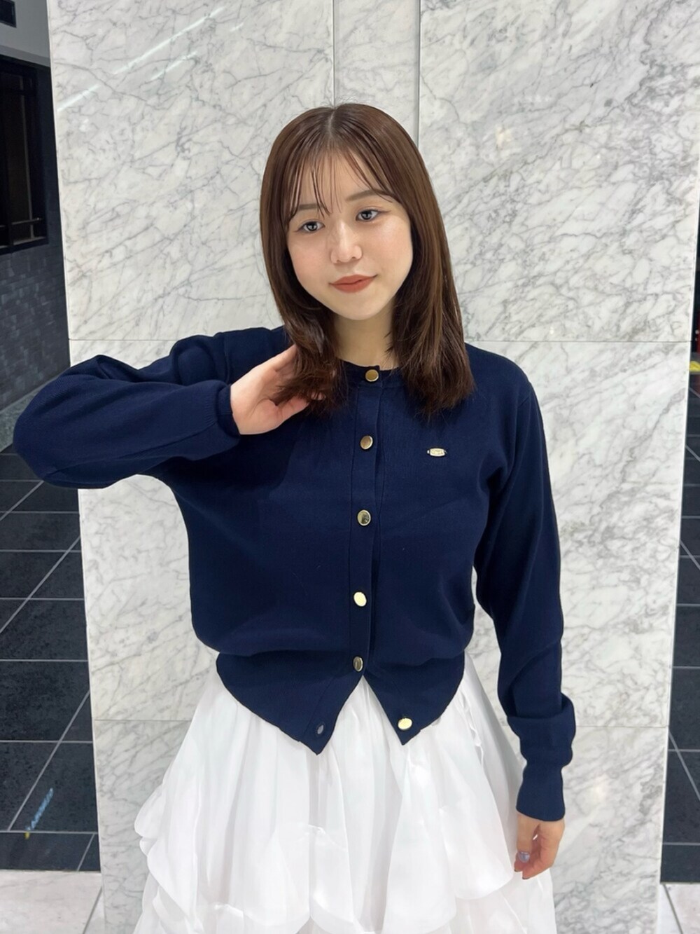 ブルー系のカーディガン/ボレロ、ホワイト系のスカート、ホワイト系のブーツを着用したレディースの秋コーディネートの7枚目の写真