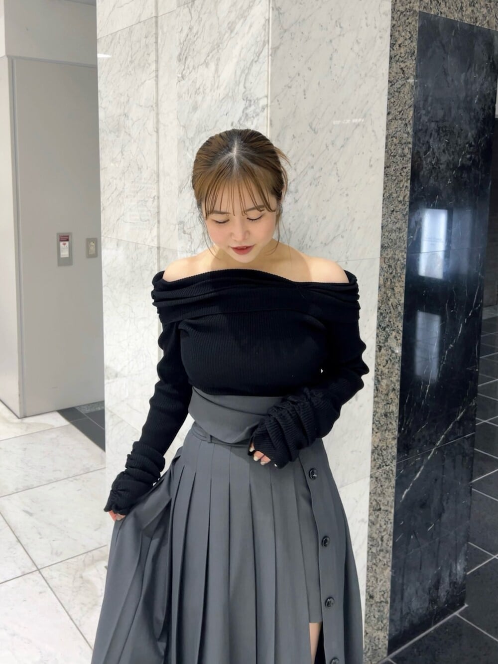 ブラック系のニット/セーター、グレー系のスカート、ブラウン系のブーツを着用したレディースの秋コーディネートの4枚目の写真