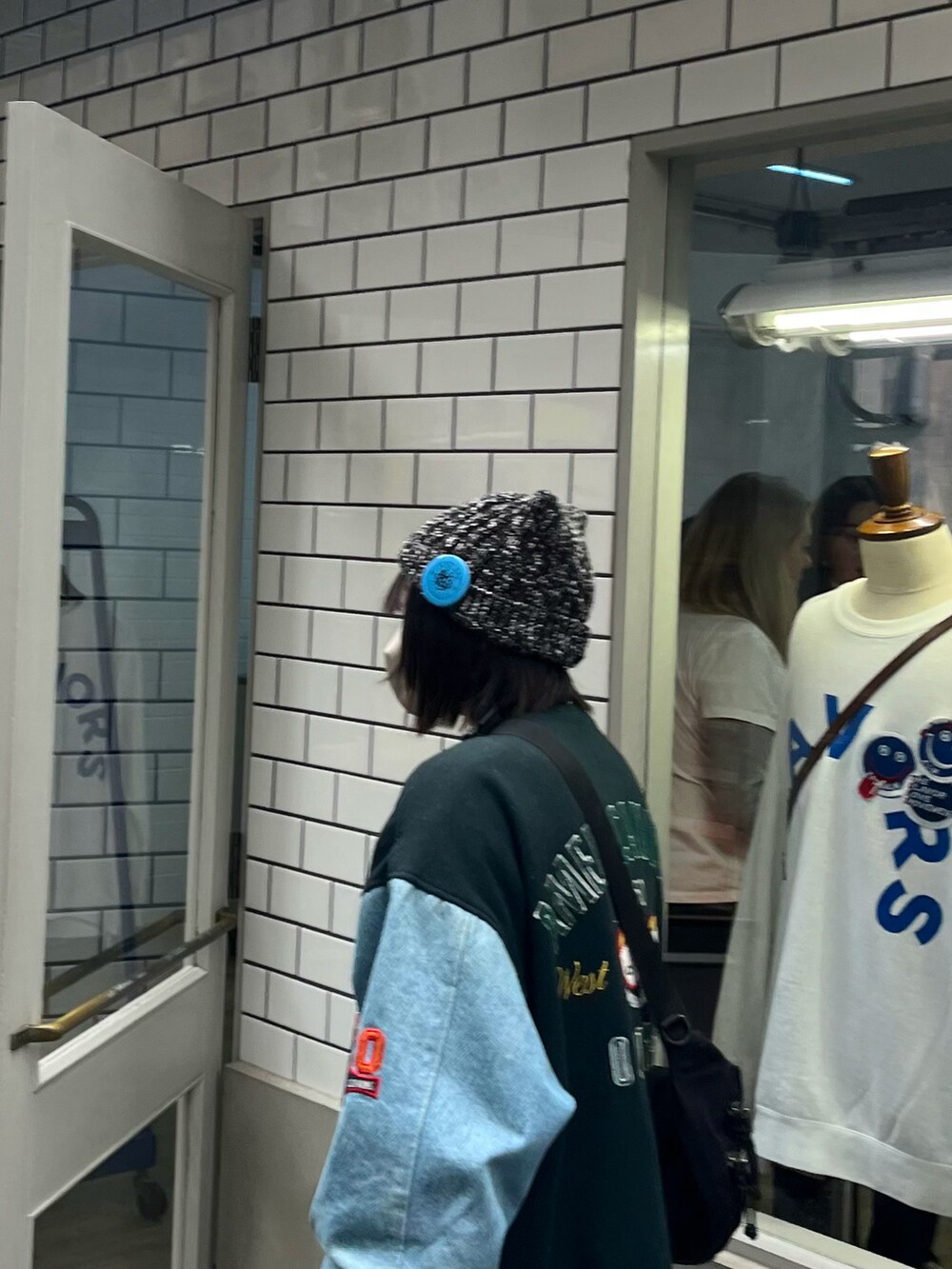 ブラック系のスニーカー、ブラック系のショルダーバッグ、グレー系のスカートを着用したレディースの冬コーディネートの2枚目の写真