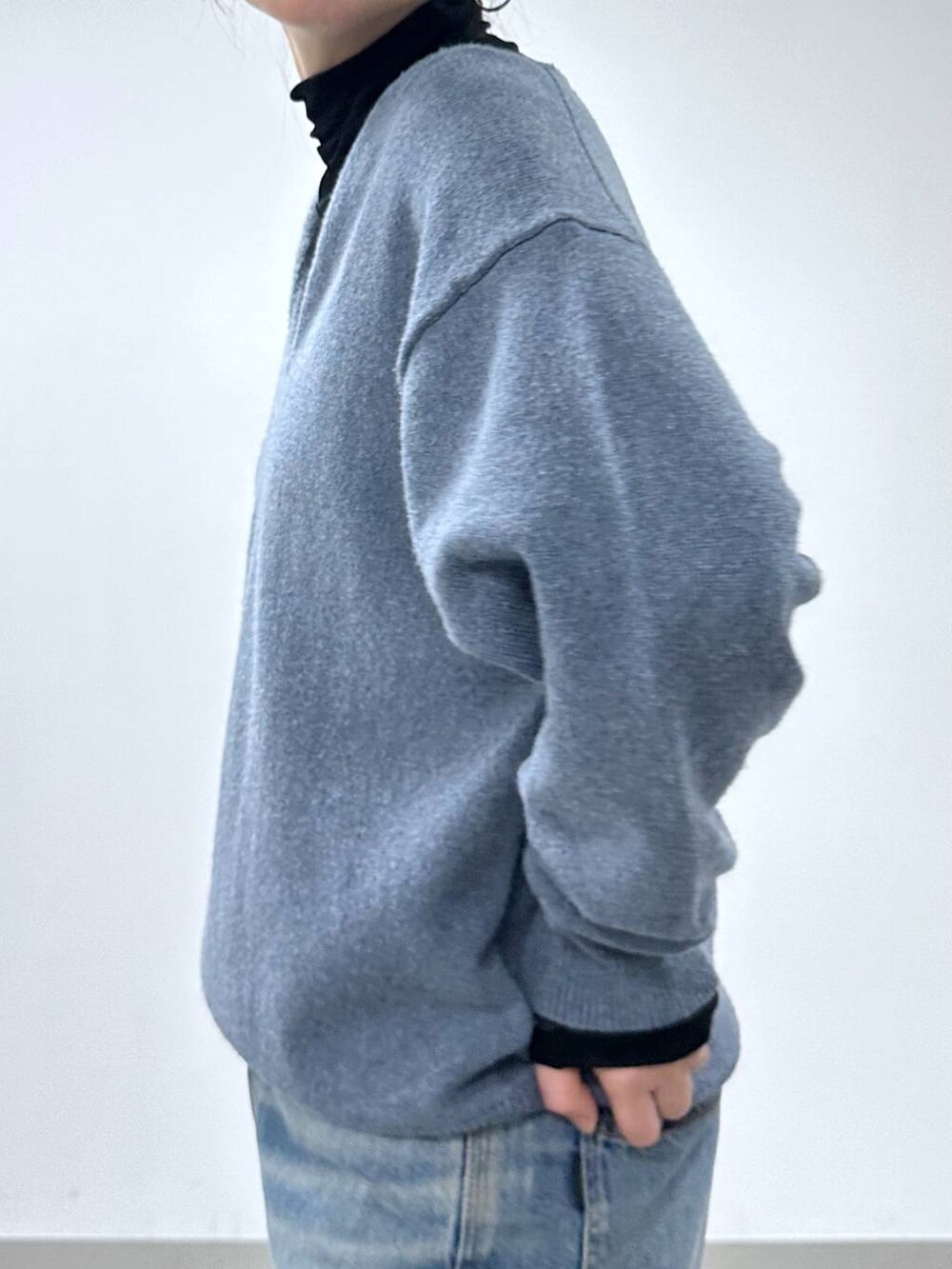 ブルー系のデニムパンツ、ホワイト系のショルダーバッグ、ブラック系のTシャツ/カットソーを着用したレディースの冬コーディネートの4枚目の写真