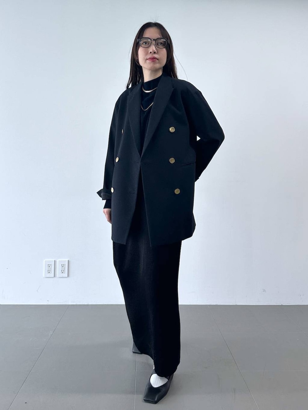 ブラック系のスカート、ブルー系のテーラードジャケット、ブルー系のニット/セーターを着用したレディースの冬コーディネートの2枚目の写真