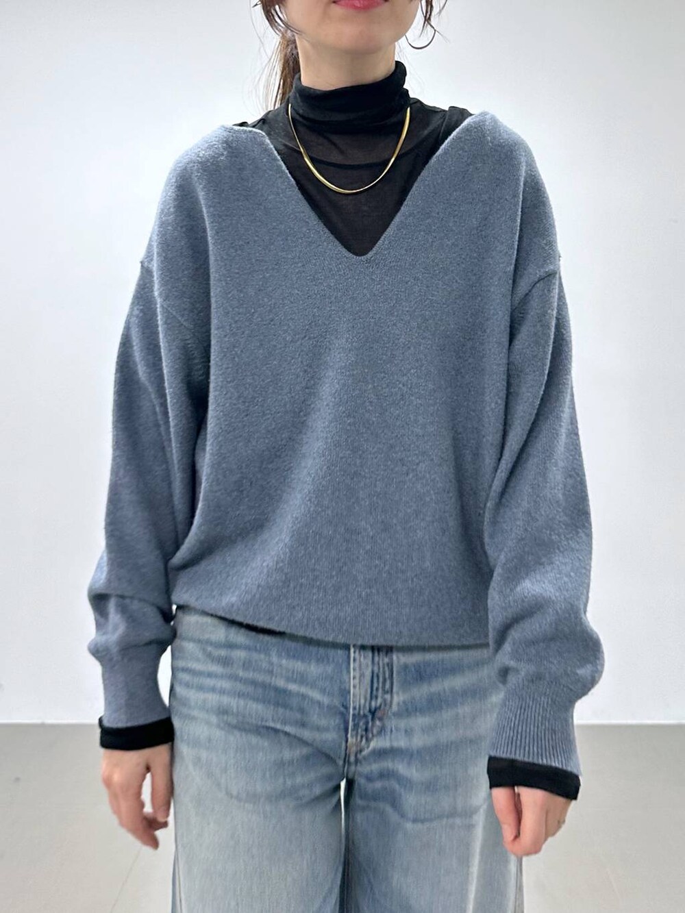 ブルー系のデニムパンツ、ホワイト系のショルダーバッグ、ブラック系のTシャツ/カットソーを着用したレディースの冬コーディネートの5枚目の写真