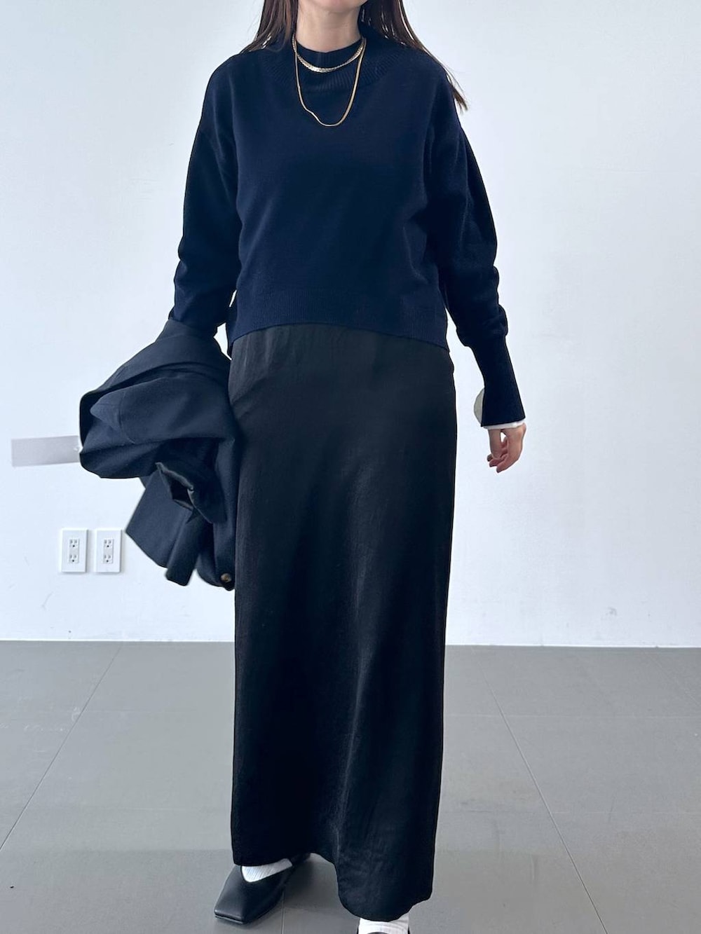 ブラック系のスカート、ブルー系のテーラードジャケット、ブルー系のニット/セーターを着用したレディースの冬コーディネートの3枚目の写真