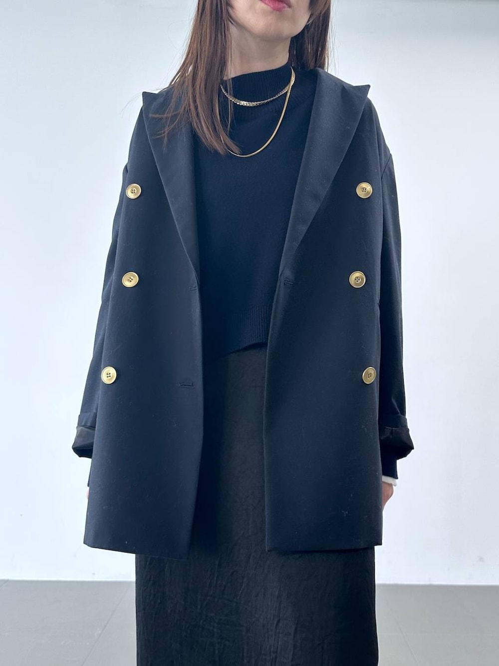 ブラック系のスカート、ブルー系のテーラードジャケット、ブルー系のニット/セーターを着用したレディースの冬コーディネートの4枚目の写真