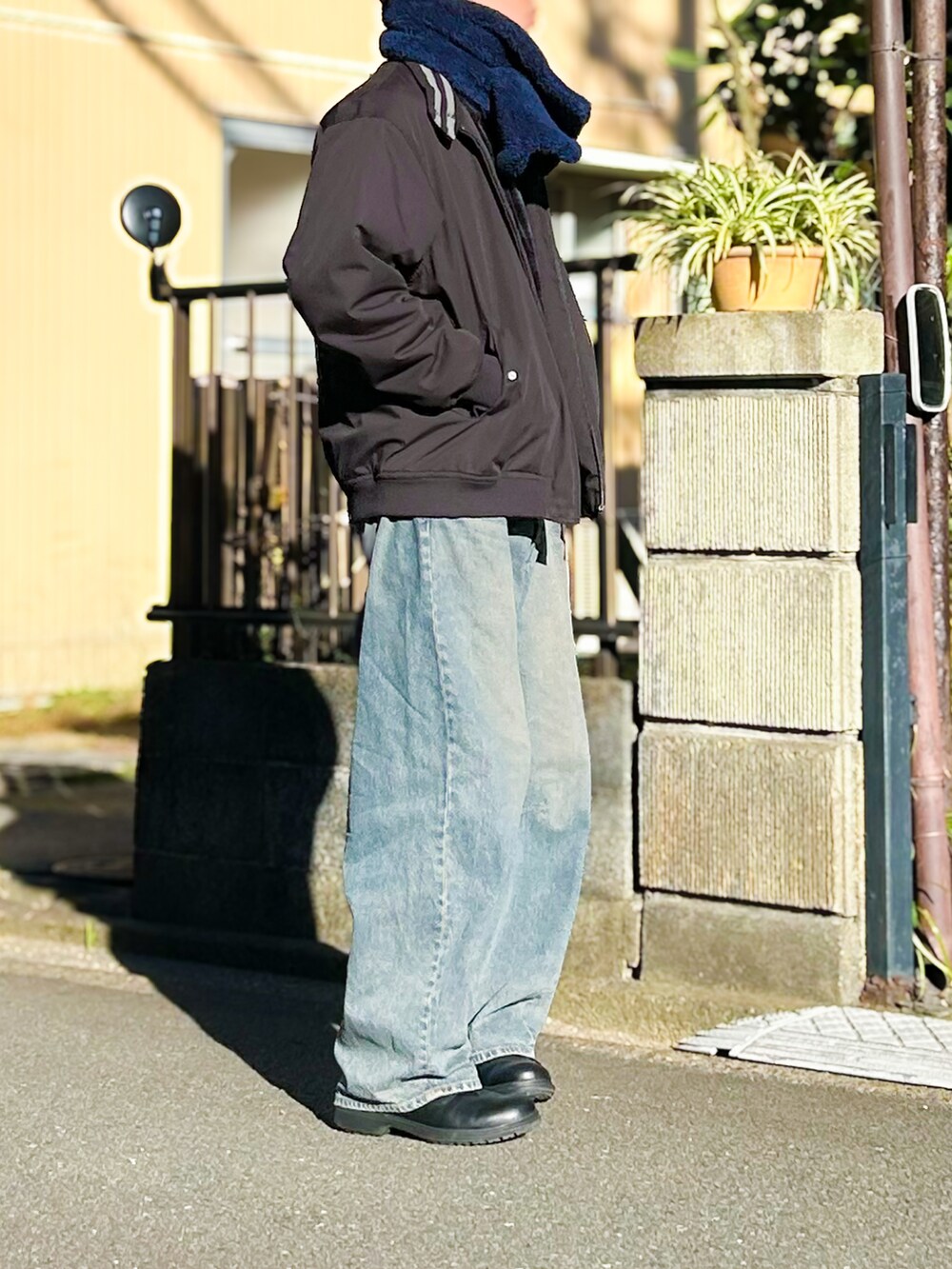 ブラック系のニット/セーター、ブルー系のデニムパンツ、ブラック系のシューズを着用したメンズの秋コーディネートの3枚目の写真