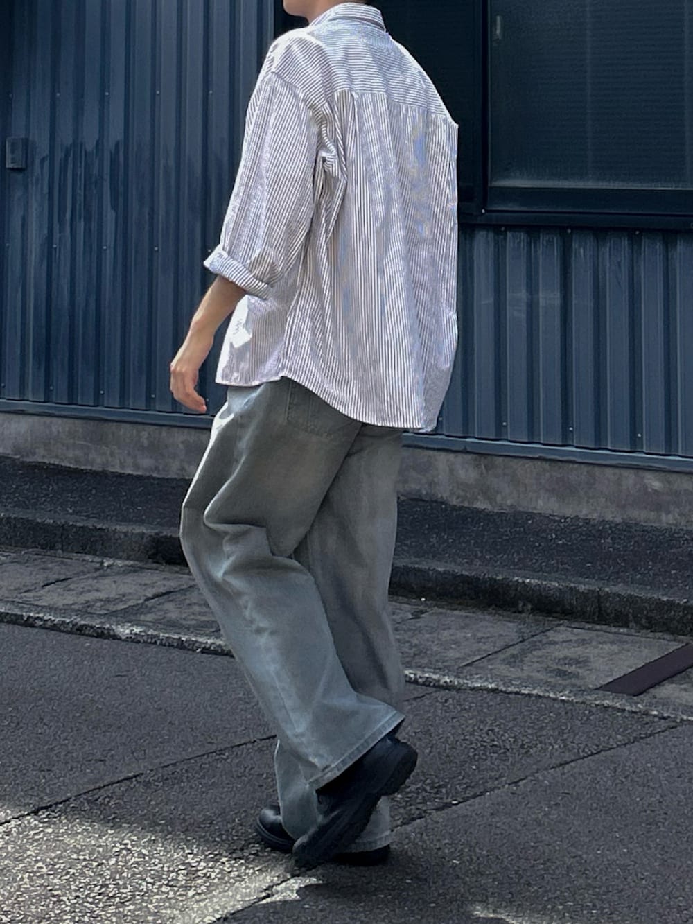 グレー系のシャツ/ブラウス、ブルー系のデニムパンツ、ブラック系のシューズを着用したメンズの夏コーディネートの3枚目の写真
