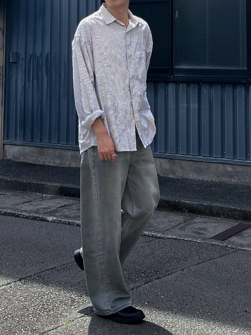 グレー系のシャツ/ブラウス、ブルー系のデニムパンツ、ブラック系のシューズを着用したメンズの夏コーディネートの2枚目の写真